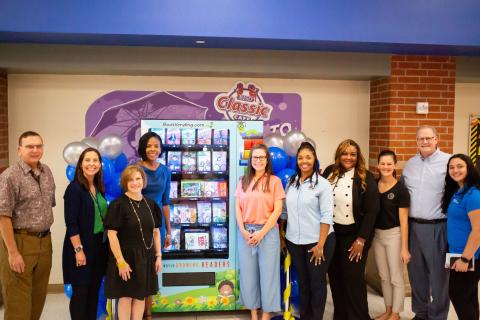 Group of people standing by a Book Vending Machine in a school